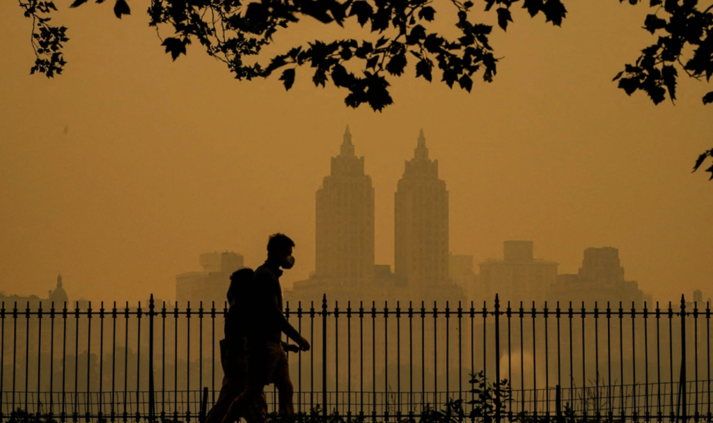 People walk in Central Park as smoke from wildfires in Canada cause hazy conditions in New York on June 7.